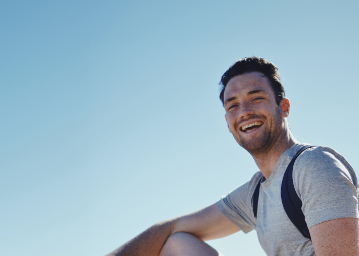 Image of a happy man with a blue sky in the background.